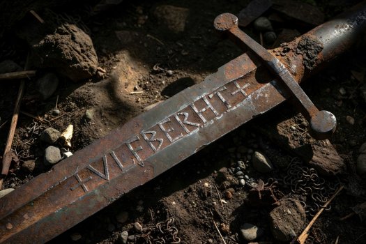 Render of an excavated Ulfberht double-edged sword showing inlaid iron letters in the blade fuller